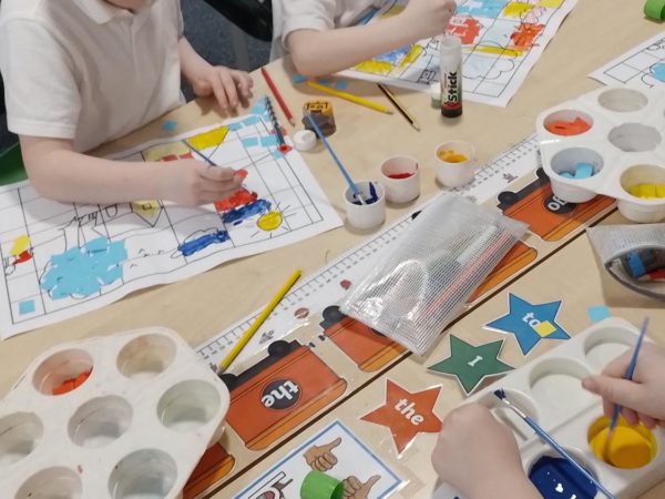 Benny and Ozzy from Rowan Primary School enjoy painting collages as part of their Art lesson.