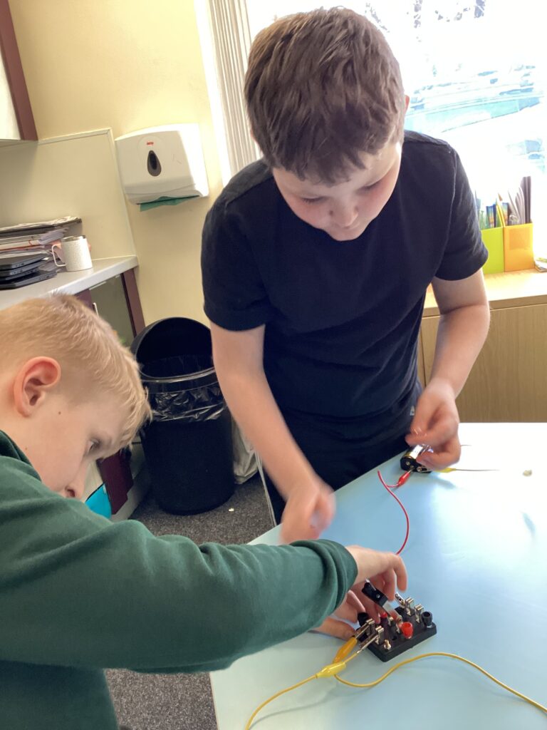 Learners building and testing simple electrical circuits in the classroom